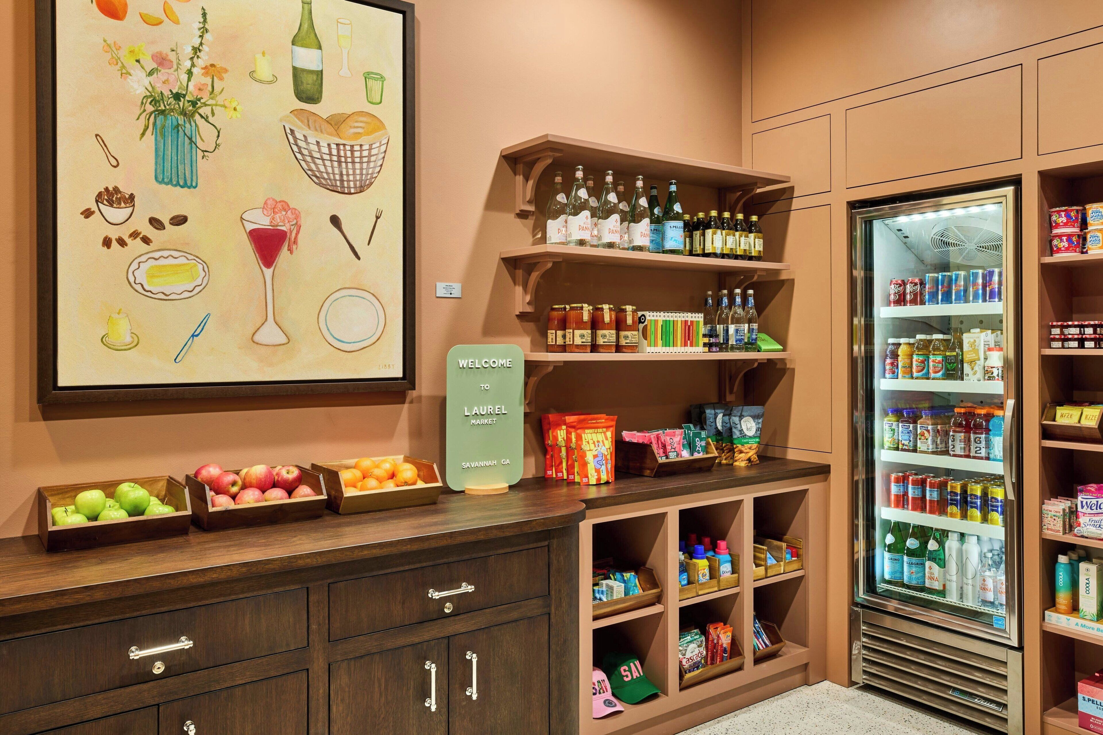 A well-organized kitchenette with a variety of food items, a refrigerator stocked with beverages, and a welcome sign.