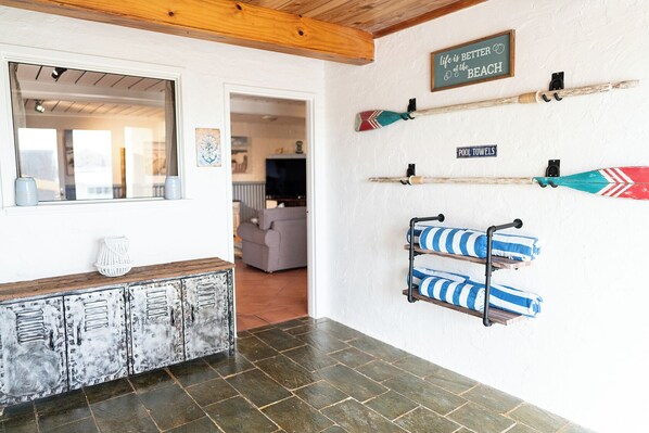 A bathroom with a rustic wooden bench, a towel rack with striped towels, and a sign that reads "life is better at the beach". - Beachfront apartment with pool, 4 minutes walk to Indian Ocean. Sleeps 6 (Quinns Rocks)