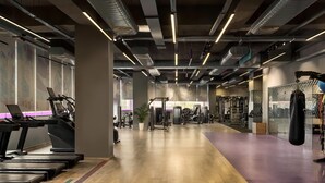 A gym with treadmills, weight machines, and a punching bag. - Ramada Encore by Wyndham Gurugram Dwarka Expressway (Gurugram)
