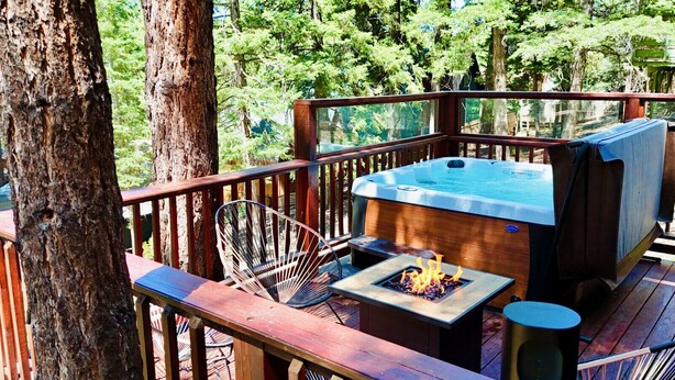 A deck with a hot tub, a fire pit, and outdoor furniture. - TreeLicious | Jacuzzi, Cozy Chalet close to Slopes (Big Bear Lake)
