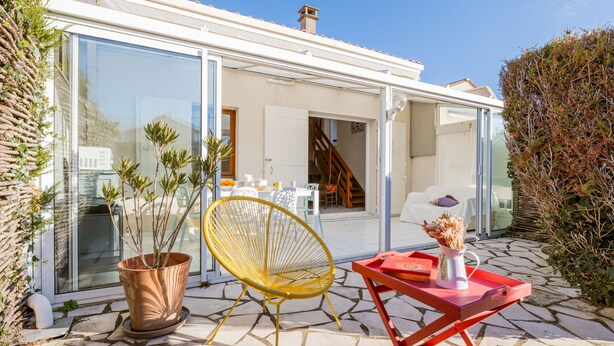 Una casa moderna con una puerta de vidrio que da a un patio.