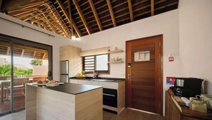 A modern kitchen with a wooden ceiling, a large island, and a view of the outdoors. - Single Tropical Pool Villa (MOOREA MAIAO)
