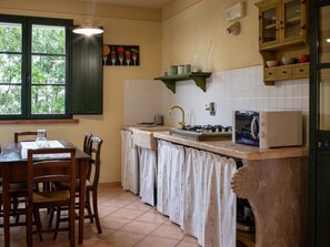 Een koelkast, een oven, kookgerei, borden en bestek