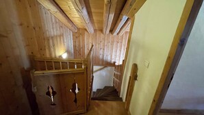 A wooden staircase with a handrail, leading to a landing with a door. - Chalet soleil ski in ski out (La rosiere)