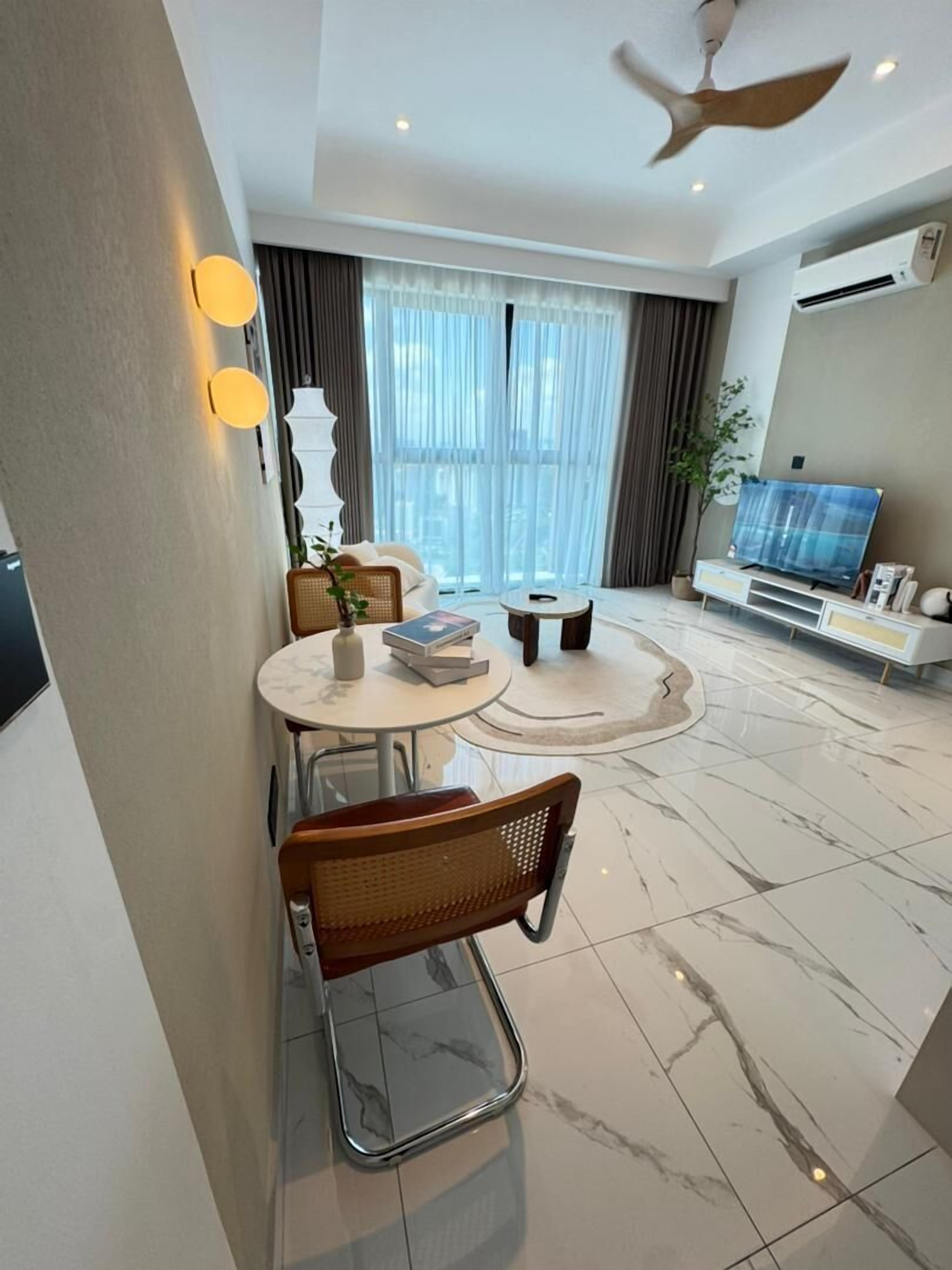Una sala de estar moderna con comedor, ventilador de techo y televisor de pantalla plana.