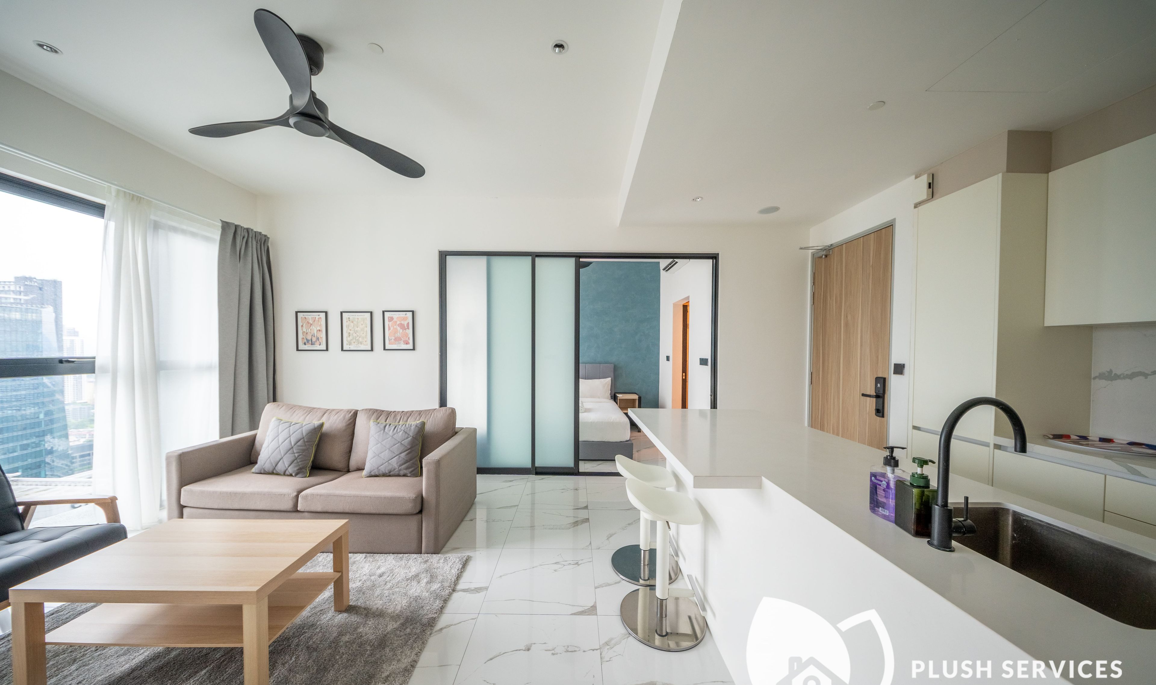 Ein modernes Wohnzimmer mit Sofa, Couchtisch und Deckenventilator.