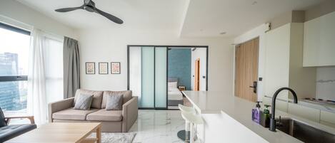 Un salon moderne avec un canapé, une table basse et un ventilateur de plafond.