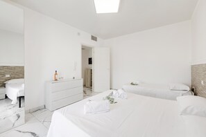 Una camera d'hotel moderna con un letto grande, un comodino, uno specchio e un armadio.