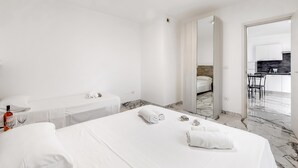 A modern hotel room with a large bed, a separate bathroom, a dining area, and a view of the kitchen. - Pino 6 - 2 bedrooms Near The Sea, Nardò, Italy (Nardò)