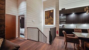 A modern interior with a staircase, a dining area, and a kitchen.