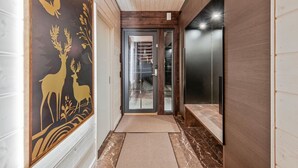 A hallway with a wooden ceiling, a glass door leading to a room, and a wall with a deer and bird mural.