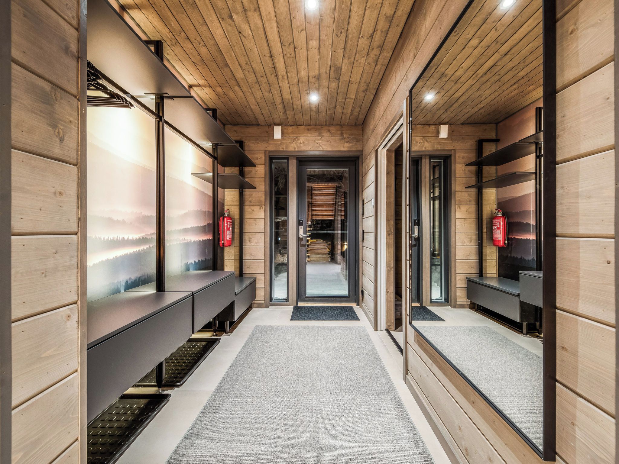 A modern interior with wooden paneling, a central corridor, and benches along the walls.