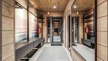 A modern interior with wooden paneling, a central corridor, and benches along the walls.