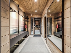 Un interior moderno con paneles de madera, un corredor central y bancos a lo largo de las paredes.