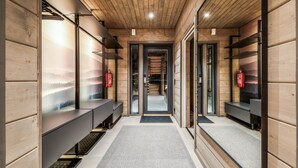 Un interior moderno con paneles de madera, un corredor central y bancos a los lados.