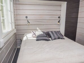 A bed with a headboard, two bedside lamps, and a window. - Kiehtäjän kuohu by Interhome (Kuusamo)