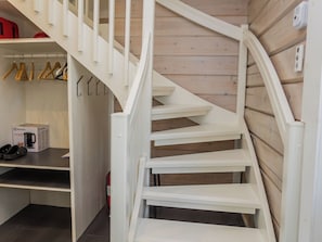 Eine weiße Wendeltreppe in einem Raum mit Holzwandverkleidung.