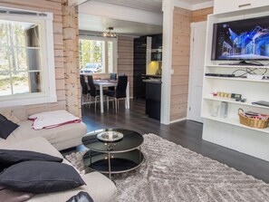 A modern living room with a sofa, a coffee table, and a television. - Kiehtäjän kuohu by Interhome (Kuusamo)