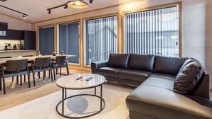 A modern living room with a sofa, coffee table, and dining area. - Villa plywood by Interhome (Pudasjärvi)