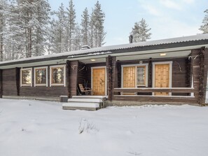 A wooden cabin with a porch, large windows, and a snow-covered landscape. - Teknomaja by Interhome (Äkäslompolo)