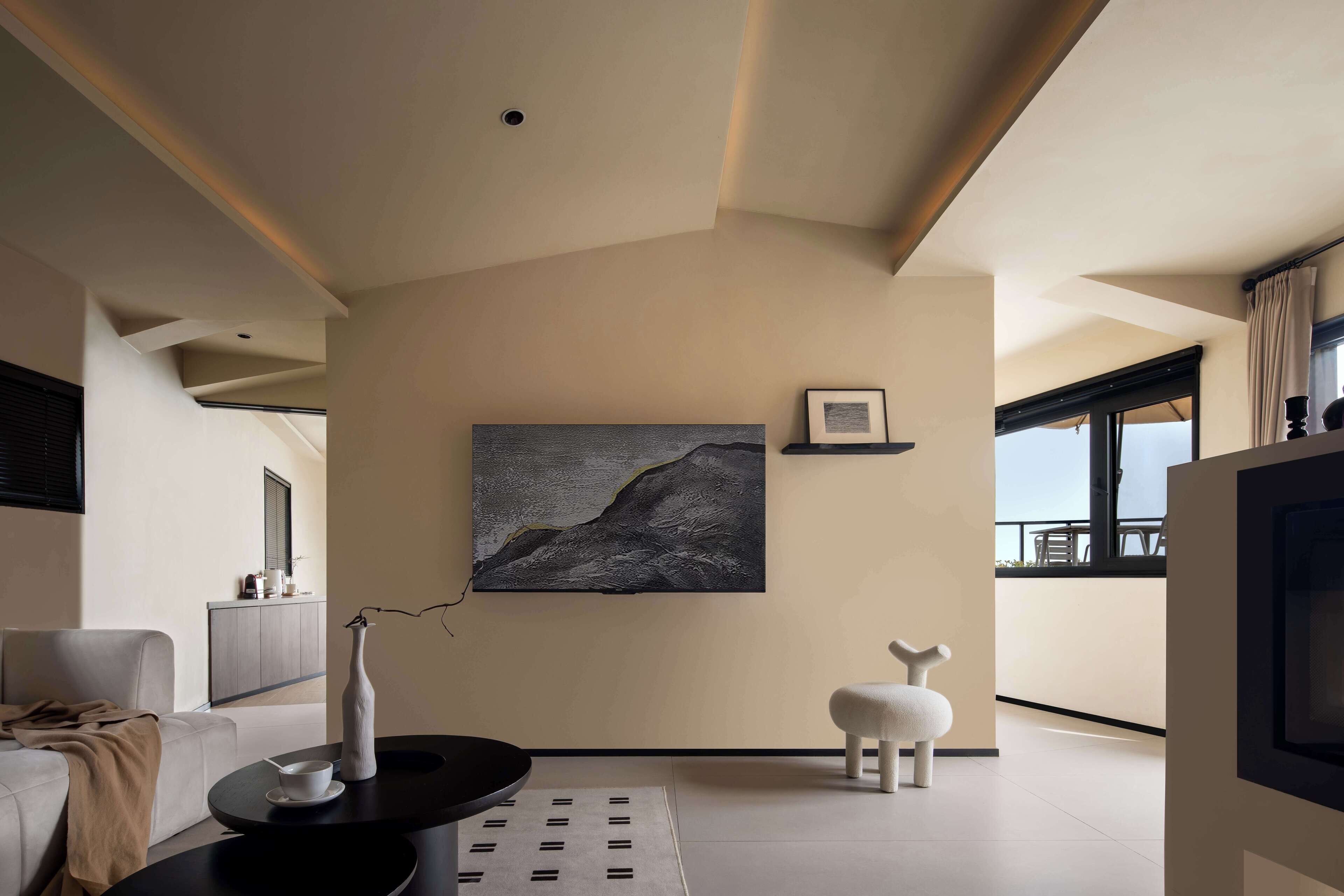 Een moderne woonkamer met een minimalistisch design, met een bank, een salontafel, een schilderij en een unieke witte stoel.