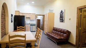A compact living space with a dining area, a sofa, and a kitchen. - The Leadville Bunkhouse (Leadville)