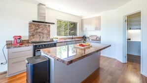 A modern kitchen with granite countertops, stainless steel appliances, and a large window providing natural light. - 94 Aldebaran Rd.  (Ocean Grove)