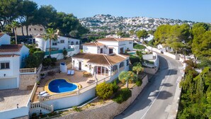 A residential area with houses, a curved road, and a swimming pool.