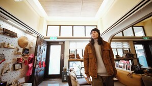 A room with a high ceiling, large windows, and a variety of items displayed on the walls. - Moker House  (Jincheng)
