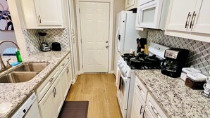 A kitchen with white cabinets, a granite countertop, a stove, a microwave, and a dishwasher. - House 3-Bedroom 2-Full Baths FREE Garage Parking, Washer, Dryer in The Woodlands (Spring)