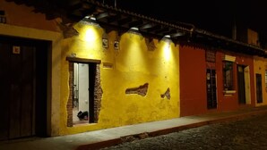 A building with a yellow facade, a visible door, and a cobblestone street.