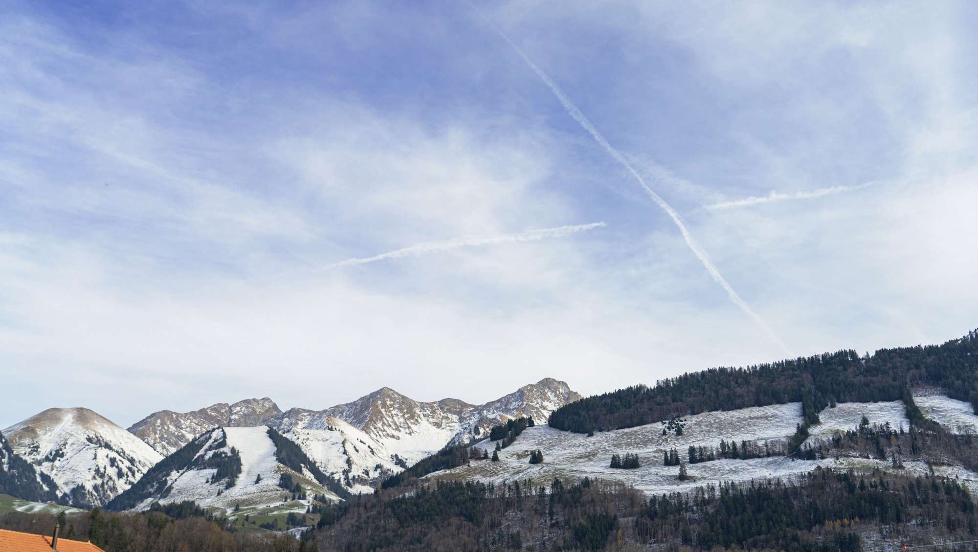 A mountainous landscape with snow-covered peaks and a clear sky.