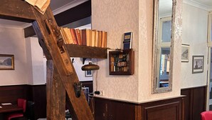A bar area with a wooden staircase, a black leather chair, and a mirror.