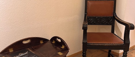 Un banco de madera con una placa y una silla de madera oscura con cojines de cuero.
