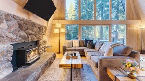 Una sala de estar acogedora con chimenea de piedra, un sofá y una mesa de centro.