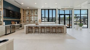 A modern kitchen with a large island, bar stools, and a view through large windows. - INCREDIBLE Views Capital +MTN+City! Penthouse cnr suite! Best Amenities! (Salt Lake City)