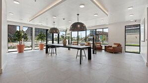 A spacious, modern interior with a central table, multiple seating areas, and large windows offering views of the outside. - INCREDIBLE Views Capital +MTN+City! Penthouse cnr suite! Best Amenities! (Salt Lake City)