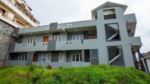 Un hôtel à plusieurs étages doté d’une architecture moderne, avec des balcons, un escalier et une variété de styles de fenêtres.