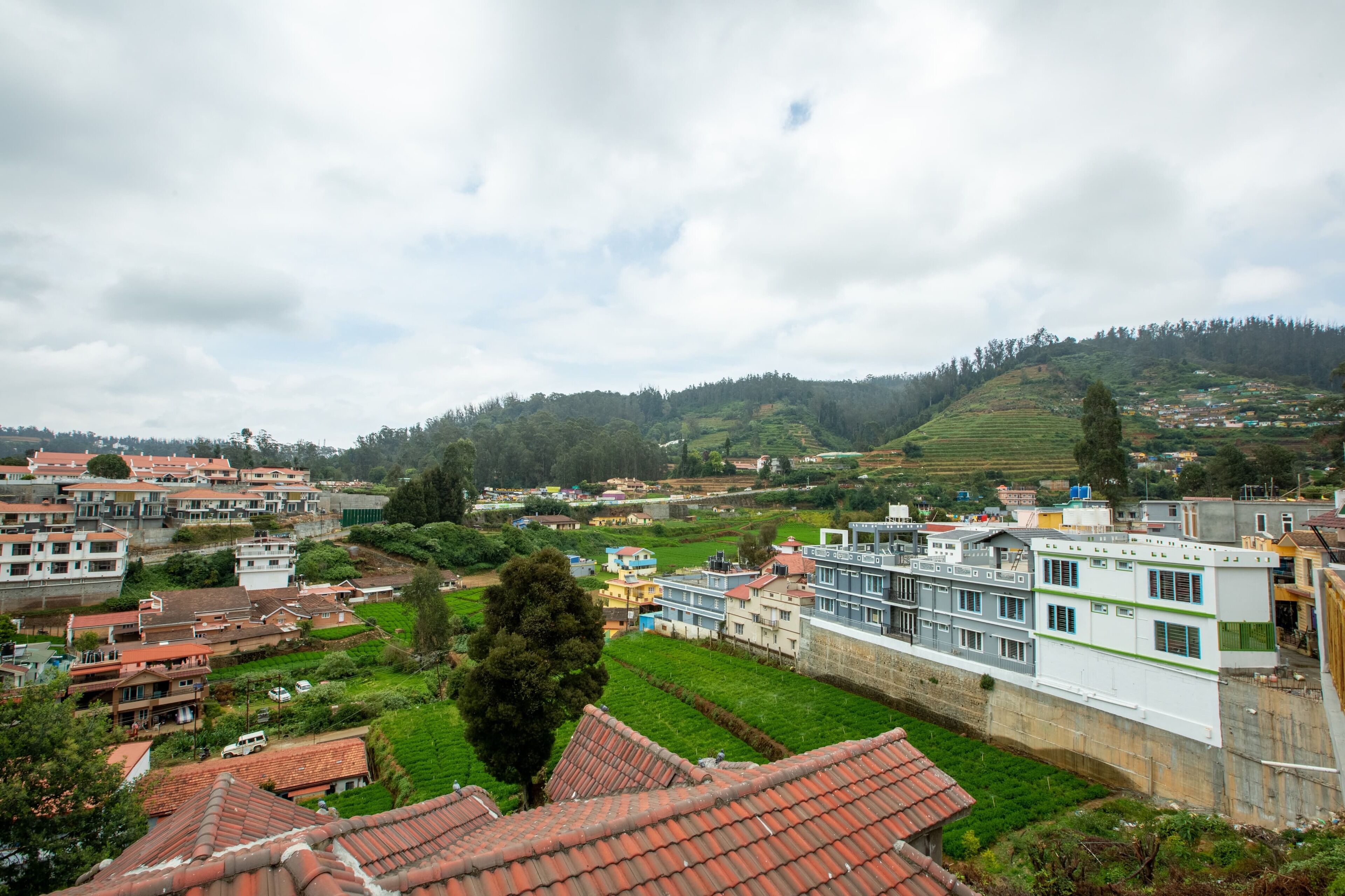 A residential area with terraced houses, a mix of modern and traditional architecture, and a hilly backdrop.