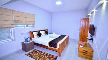 A bedroom with a wooden bed, a bedside table, a TV, and a window with blinds.