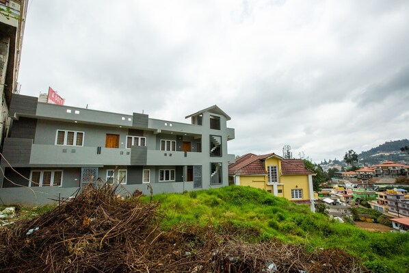 A multi-story building with a modern design, featuring balconies and a staircase.