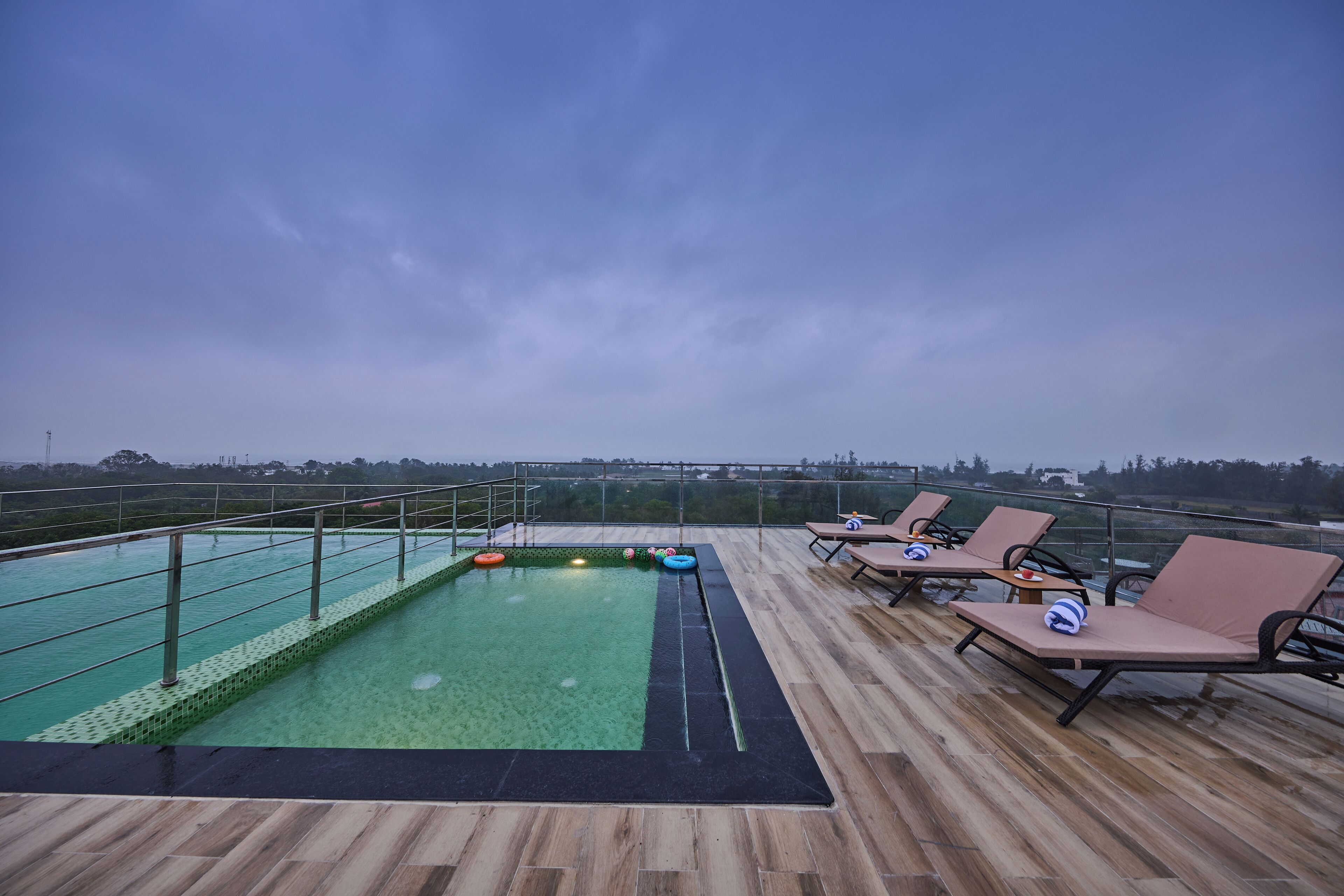 A rooftop pool area with lounge chairs and a pool.