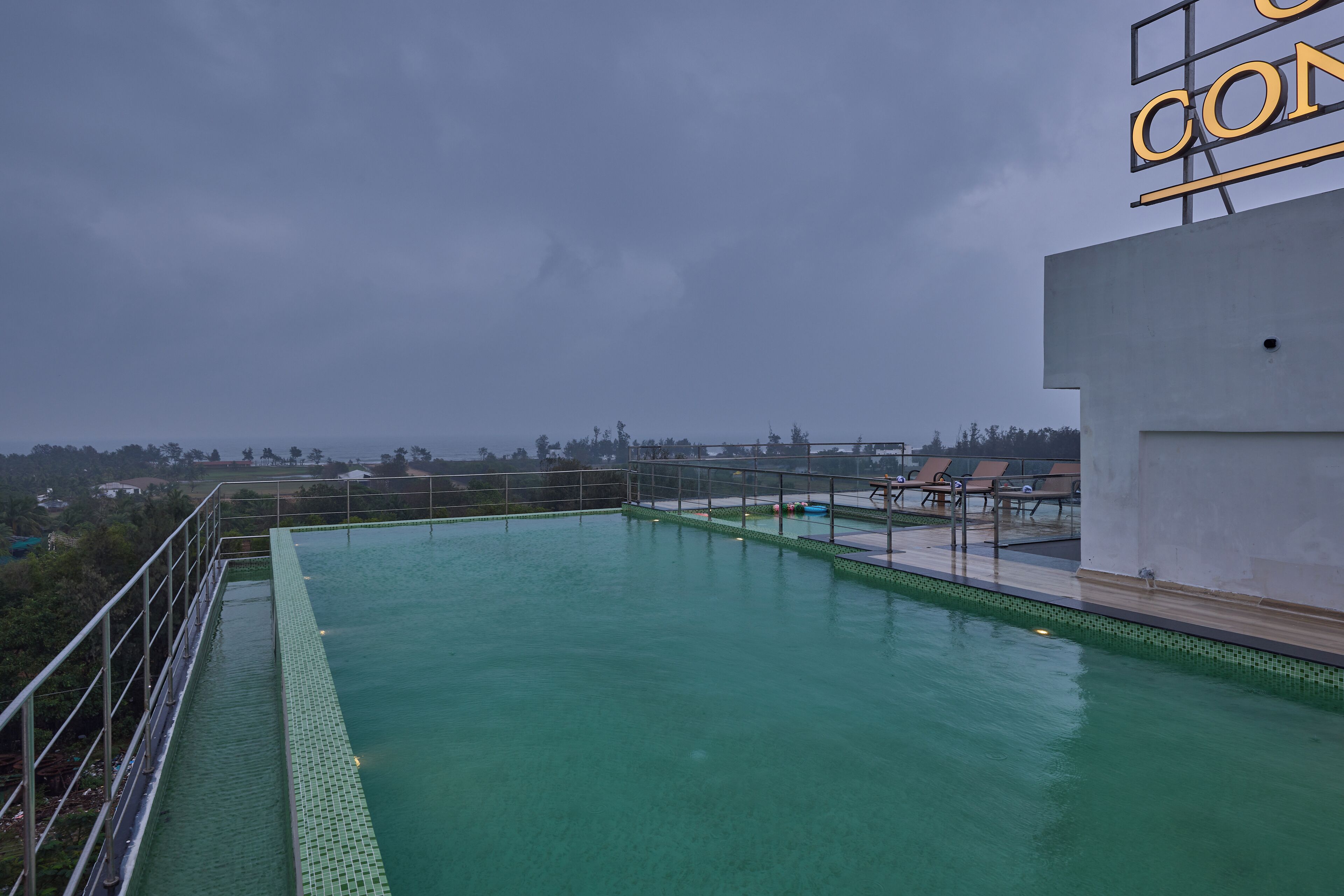 A rooftop swimming pool with a view of the city skyline.