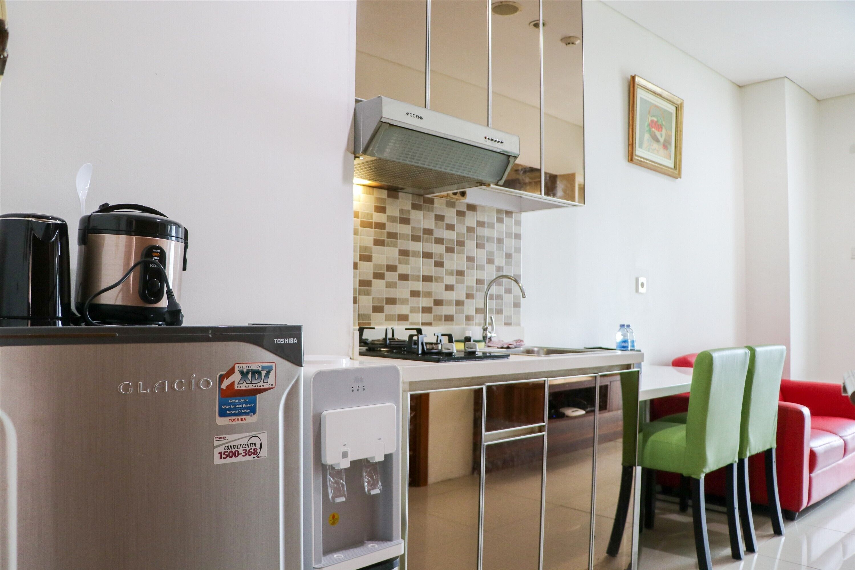 Cocina compacta con refrigerador, cafetera y dispensador de agua.
