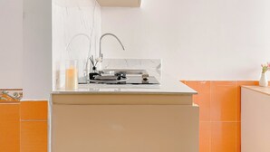Eine moderne Küche mit Marmorfliesenspiegel, Spüle aus Edelstahl und einer kleinen Arbeitsfläche.