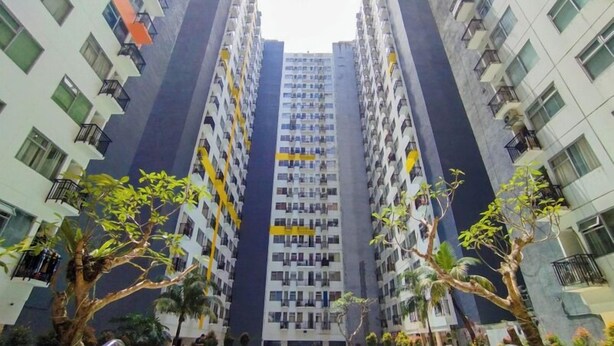 A high-rise residential building with multiple balconies, surrounded by trees. - Stylish And Spacious Studio At Apartment Jarrdin Cihampelas (Bandung)