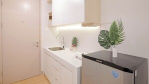 Une cuisine moderne avec des armoires blanches, un réfrigérateur en acier inoxydable et un évier.