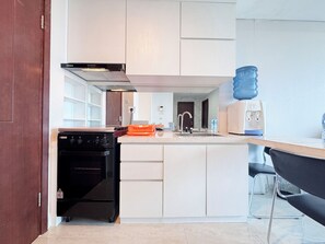 Apartment | Private kitchen | Full-sized fridge, stovetop, rice cooker, dining tables - Strategic 2Br With City View At Grand Sungkono Lagoon Apartment (Surabaya)