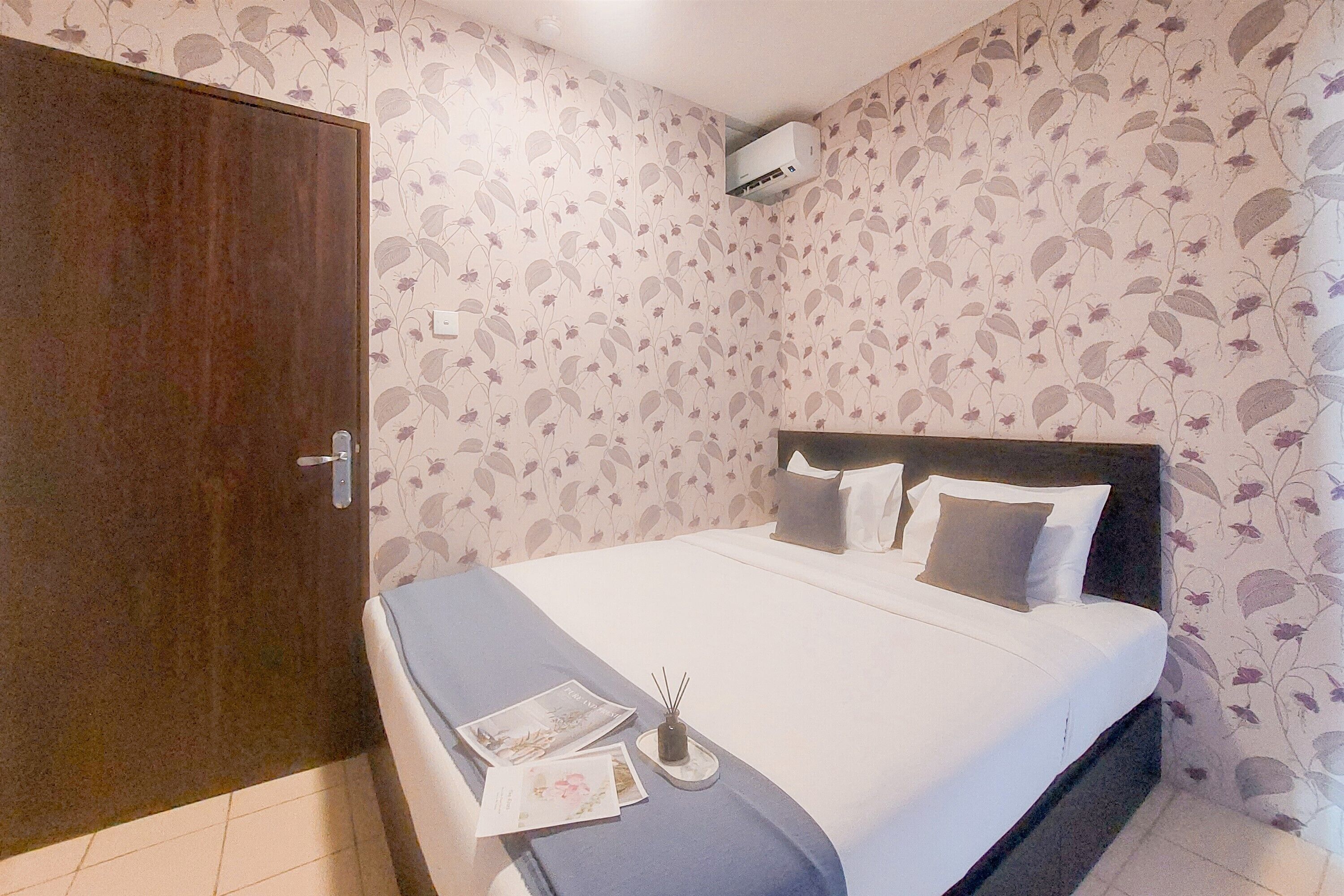 Ein Schlafzimmer mit einem Bett, einem Kleiderschrank und blumigem Wandpapier.