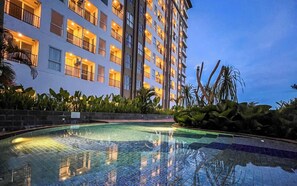 Un hotel con piscina rodeado de plantas tropicales.